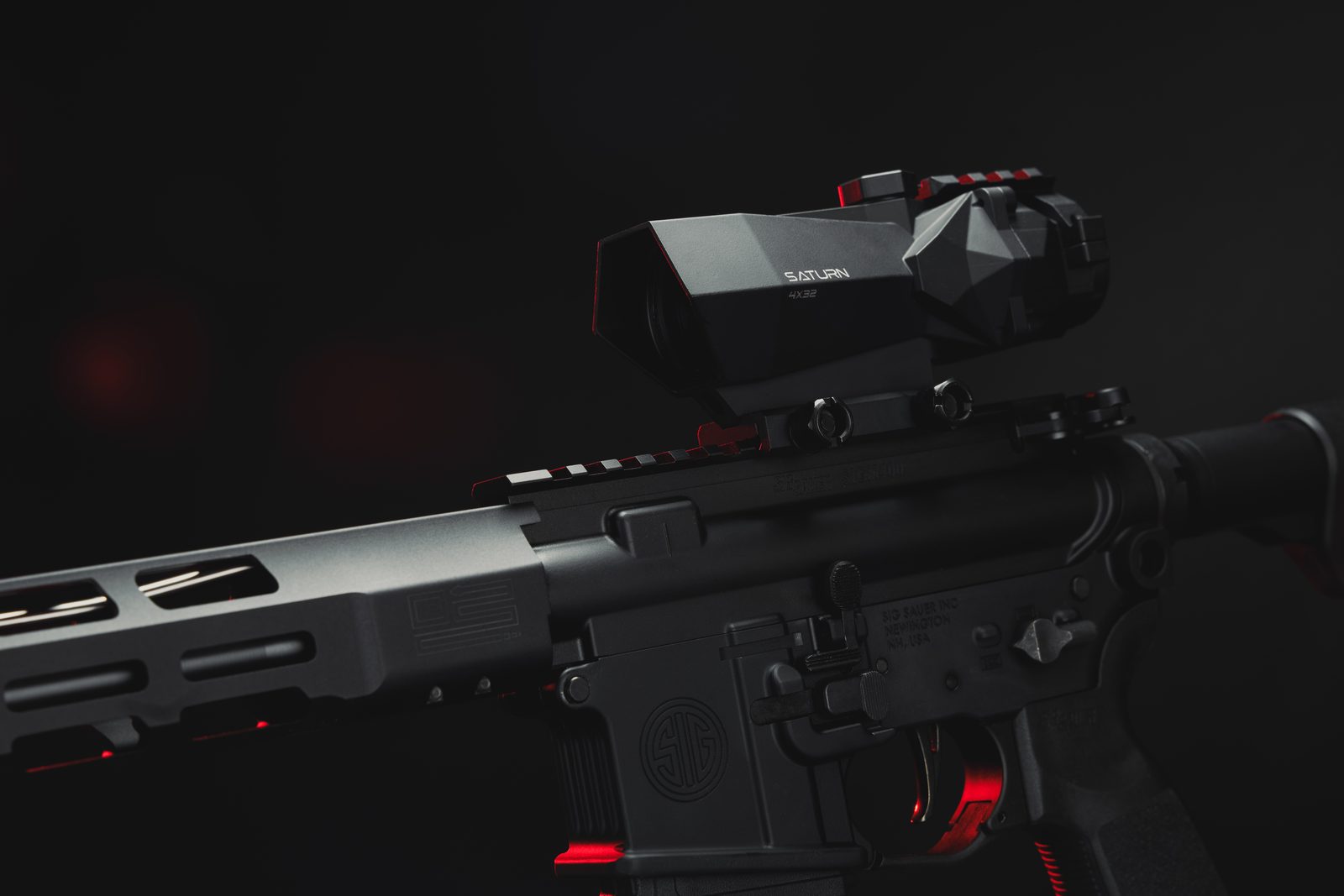 Saturn 4x32 prismatic scope mounted on an AR-15, studio shot with red rim lighting